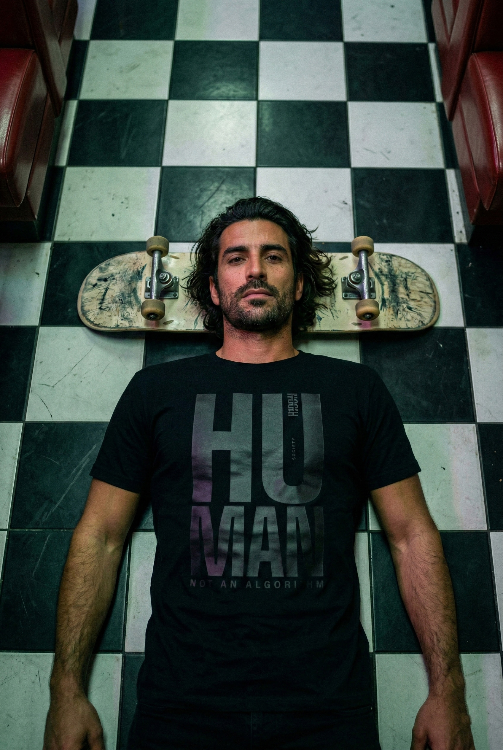 Person wearing a H1DDN shirt on a monochrome tiled floor